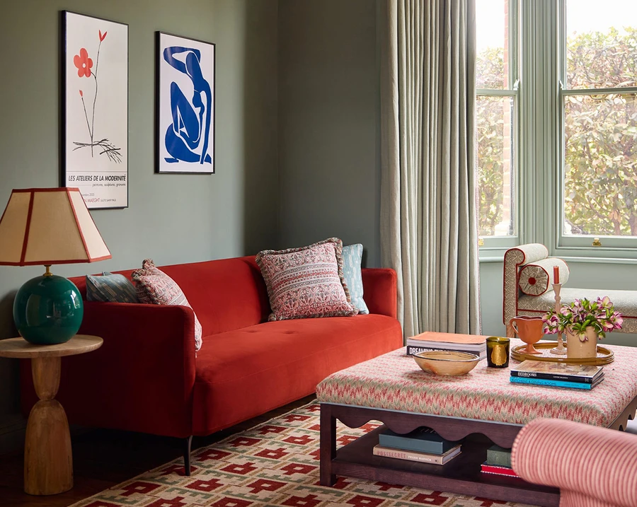 Комната с зелеными стенами и красным диваном