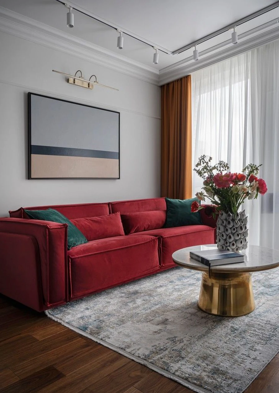 Комната отдыха с красным диваном и золотым столом